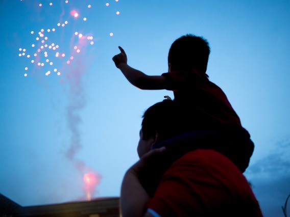 man and child watching fireworks